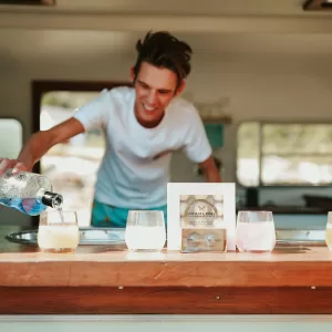 Professional bartender serving drinks and managing bar setup at an event.